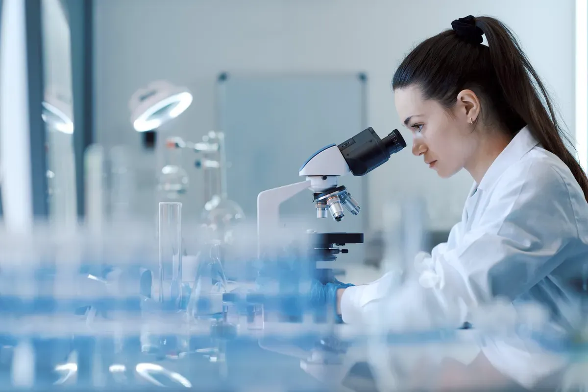 A researcher working at a microscope in a laboratory